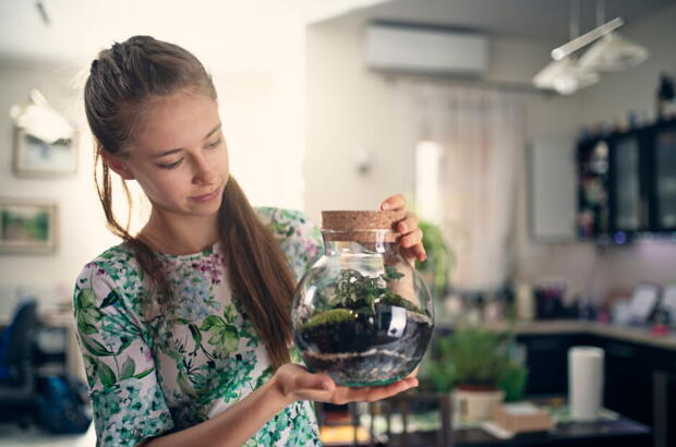 Mädchen hält den fertigen Flaschengarten in der Hand | VELUX Magazin