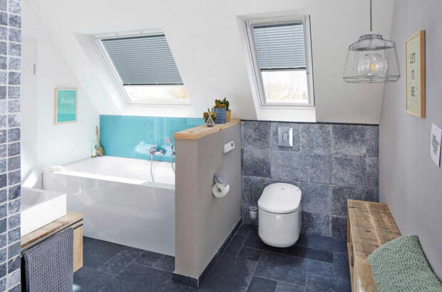 Deux fenêtres de toit dans la salle de bains avec des carreaux noirs | Magazine VELUX