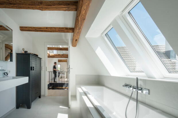 Salle de bains avec poutres en bois et deux fenêtres de toit | Magazine VELUX