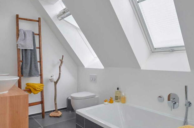 Deux fenêtres de toit dans une salle de bains grise | Magazine VELUX