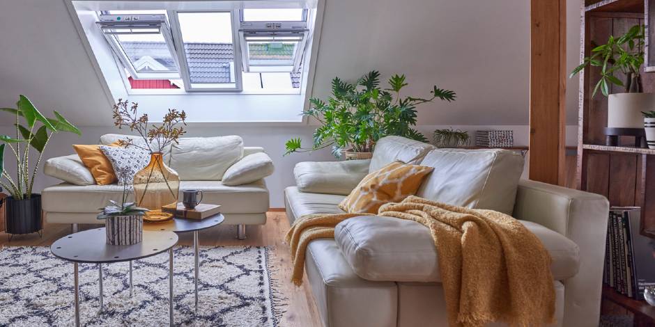 Canapé sous la fenêtre de toit dans un salon avec une pente de toit | Magazine VELUX