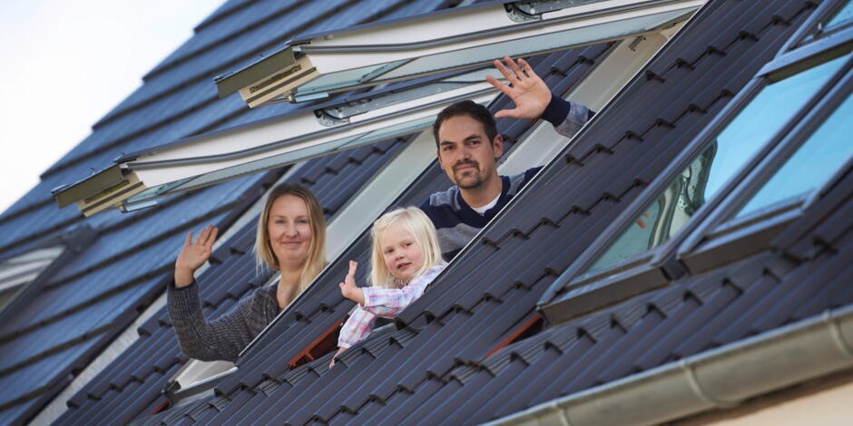 Familie guckt aus Dachfenstern des Kinderzimmers | VELUX Magazin